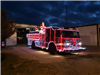 Fire Engine Lined with Christmas Lights Parked Outside the Department Garage