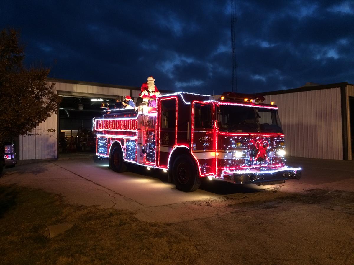 Fire Engine Lined with Christmas Lights Parked Outside the Department Garage