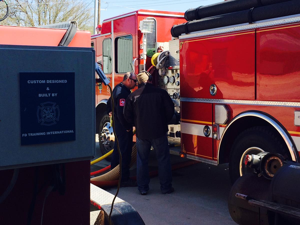 Two Officers Performing Maintenance on a Fire Engine 2